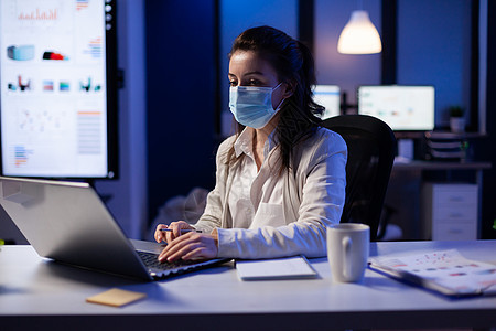 戴面罩的经理妇女 在新的正常商务办公室加班工作笔记本隔离商业互联网桌子技术团队公司人士电脑图片