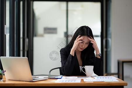 美丽的亚洲女商务人士因为在办公室工作而疲劳 妇女因工作感到压力图片
