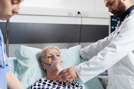 医生和护士用氧气罩监督高级妇女呼吸情况治愈复苏诊所医师男人通风女士医院住院老年图片
