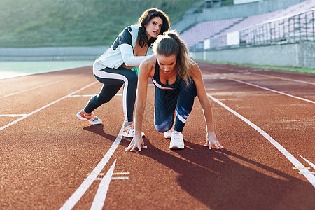 年轻运动员与私人教练一起在体育场开始锻炼 然后向前冲 为比赛做准备 跑道上的女运动员 锻炼力量 有氧运动和爆发力图片