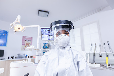 病人第一人观察身穿防冠状病毒防护器具的牙科牙医情况图片