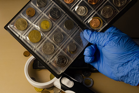 处理桌上放大镜上的硬币集合古钱币金子铸币投资成功学家金融财富金属钱币图片