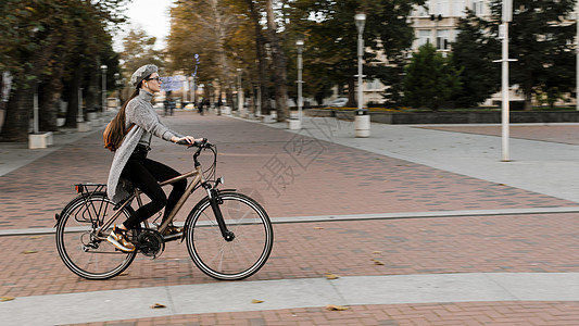 妇女骑自行车长镜头站立 高品质照片图片