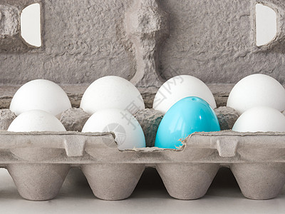 一张特写的照片 一个蓝色的塑料复活节鸡蛋 在纸板彩蛋盒里嵌套了几只真正的白鸡蛋游戏节日隐藏空间食物庆典艺术孩子们开放传统图片