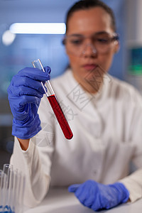 具有手头血液测试管的专业化学专业专家科学家显微镜实验样本微生物学诊所工人科学医生工作图片