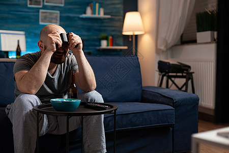 人游戏机玩运动电子游戏 控制员坐在客厅沙发上图片