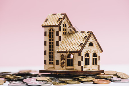 房子模型硬币前面粉红色背景 高品质照片图片