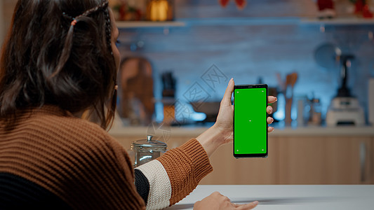 白种女人拿着绿色屏幕的智能手机图片