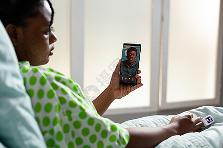 非洲种族青年病人通过视频电话交谈 校对 Portnoy诊所流感医院房间技术女孩休息诊断会议病房图片