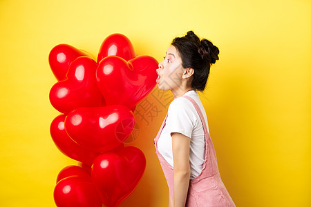 情人节和关系概念 描述年轻亚洲女性的惊喜尖叫 说哇和向左看惊讶 站在红色气球旁边 黄色背景面孔 笑声礼物女孩情感假期热情工作室伙图片