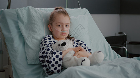 身穿氧气鼻管 卧床康复的小女孩病人的肖像诊断痛苦感染发烧诊所流感温度药物管子鼻音图片