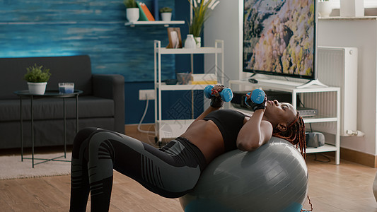 黑色皮肤的瘦黑妇女锻炼身体肌肉 进行晨出手术图片