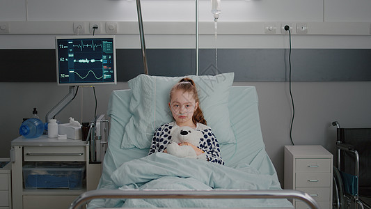 医疗咨询期间 抱着泰迪熊的住院患病女童病人在床上休息的肖像 在就诊时躺在床上病房流感保健温度治疗腮腺炎诊所发烧医院药物图片