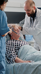 呼吸困难的女人 在床上求医救伤员图片