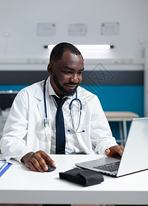 非洲看电脑屏幕的美国专家理疗治疗医生 美洲专家医师图片