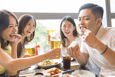 快乐的朋友们在餐厅享受食物和饮酒图片