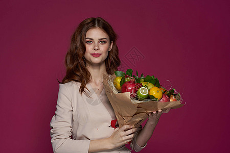 以水果花束维他命为奇特背景的快乐女人展示水果蔬菜礼物素食主义者运动饮食营养女孩作品图片