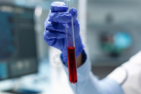 拿着有血液的透明试管的化学家研究员特写镜头图片