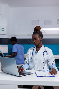 使用笔记本电脑从事医疗工作的非裔美国人医院药物女士卫生职业诊所互联网技术外套外科图片