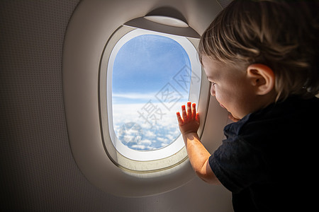 可爱的小孩在窗口中用手指指向天空 第一个飞行概念 与孩子们一起旅行 笑声窗户飞机机场乘客航班女孩空气安全运输腰带图片