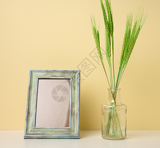 白色白桌 黄色背景上的空白木相片框和绿色植物植物群小麦桌子房子照片植物玻璃办公室装饰风格图片
