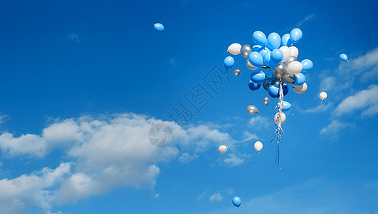 白蓝气球被放出 在蓝天高飞图片