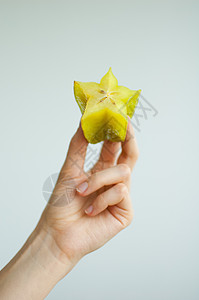女性手握着奇特的成熟恒星水果或香草果 健康食品 新鲜有机星苹果水果手臂农业橙子营养情调饮食食物星星姿势热带图片