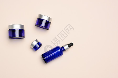 装有管子的玻璃蓝色瓶子 和底底油面上的罐头 化妆品SPA品牌模型图片