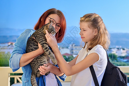 在房子的门廊上 母前女儿和猫宠物在一起女士动物幸福童年女孩乐趣父母妈妈微笑成人图片