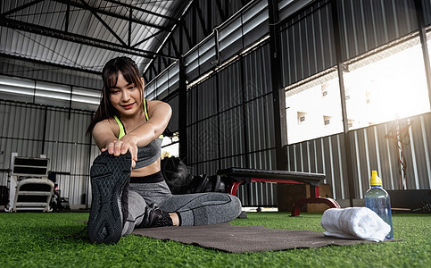 年轻的亚洲女性穿着时尚舒适的运动服 在健身地板上伸展双腿 锻炼和运动的概念 在健身房做伸展运动的健康女性护理身体运动装肌肉女士活图片