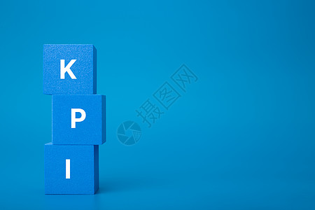 在深蓝背景和复制空间的蓝色玩具立方体堆积上的 KPI 字母审查资源一体化数据教育成就营销战略咨询职业背景