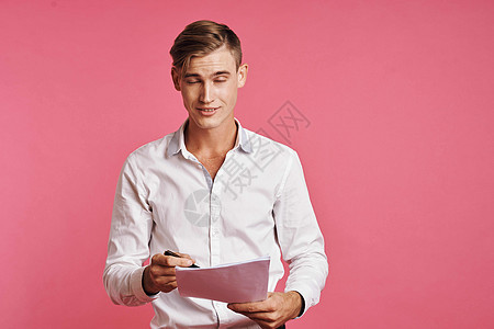 一个人用手边孤立的背景来阅读文件的肖像微笑快乐笔记本男生思考学习情感青少年衬衫考试图片