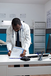 非裔美国医生分析具有疾病专业知识的文书工作图片