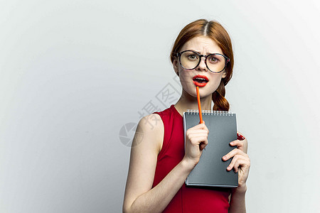 带着眼镜的开心女人 红裙子笔记工作床单企业家经理相机微笑衣领技术头发商业幸福图片