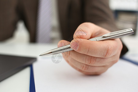 穿西装和领带的男性手臂握着银笔商务日记职业审查签名文档经理项目律师男人图片
