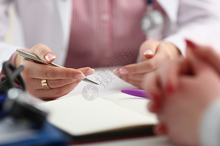 女医生手握银笔卫生文档访问帮助援助病人软垫治愈咨询商业图片