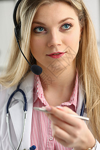 快乐笑笑的年轻医生在耳机上的肖像诊断讲话考试工作女性药品正装正方形关心工人图片