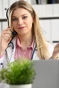 快乐笑笑的年轻医生在耳机上的肖像处方实验室关心临床咨询工人女性快乐蓝色工作图片