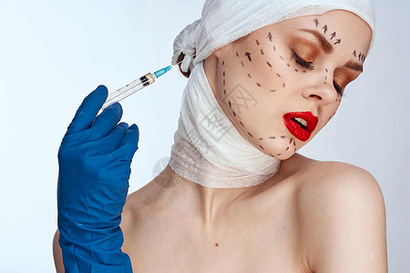 蓝手套注射器的女病人在脸部举光背景上的轮廓上医生塑料手术美容师嘴唇皱纹医院身体外科成人图片