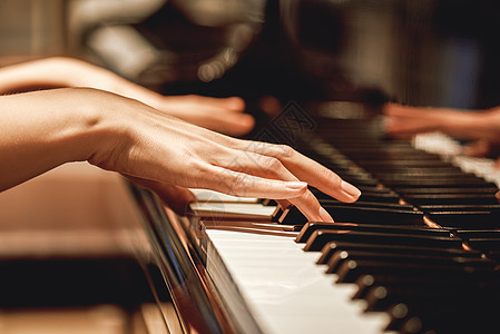 在钢琴课上 近距离观看轻柔的女手在钢琴上演奏旋律时所表现的风景图片