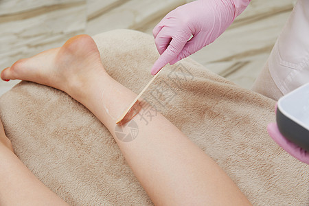 美容学家在沙龙里用凝胶 在女性腿上做激光除毛镜脱毛仪器化妆品皮肤科液体皮肤卫生美容药品护理图片