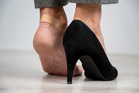 穿黑鞋的女人在玉米上贴了石膏药品伤害皮肤科皮肤组织保健愈合女孩脚跟事故图片