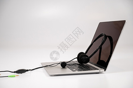 在笔记本电脑键盘上的耳机 白色背景代理人技术职场顾客商业秘书服务呼叫麦克风操作员图片