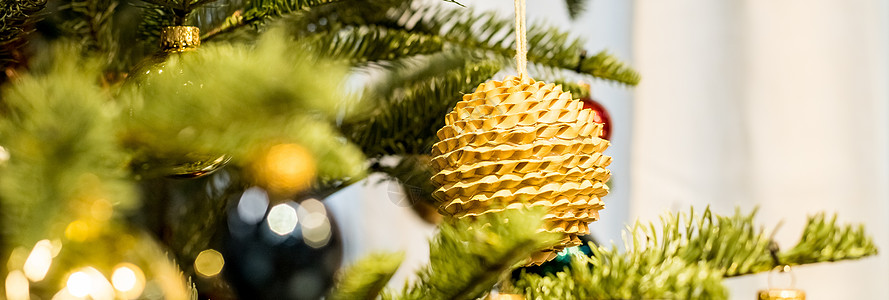 圣诞树和装饰品 生态 火花 发光的球 新年快乐 红色和金色的球和带手电筒的照明花环 树枝上的新年小玩意 寒假 网页横幅图片