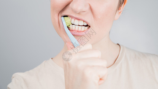 白种女人刷牙的特写肖像 女孩执行早晨口腔卫生程序快乐牙膏健康化妆品女性牙刷药品家庭生活牙齿卫生图片