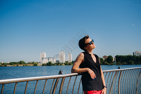 穿红西装的女孩站在湖边的码头上街道套装眼镜城市奢华女士外貌人士黑发魅力背景图片