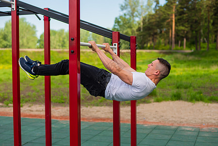 白种男人在不平坦的酒吧做背木板 在运动场上锻炼公园耐力工作平行身体运动地面健美操力量腹肌图片