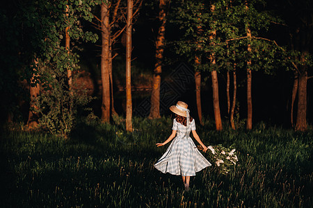 美丽的女孩在夏日享受丁香的气味 芳香疗法和春天的概念 一个漂亮的女孩 一个穿着蓝色复古长裙的漂亮女人站在淡紫色的花园里 园艺幸福图片