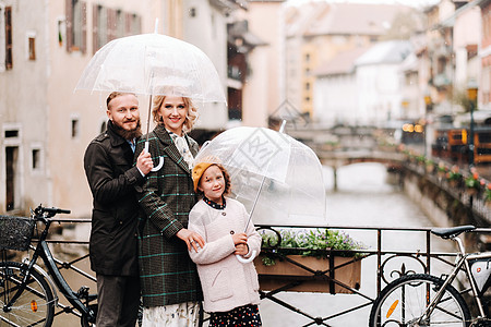 在法国安妮西的雨天下 有雨伞的美丽家庭 家庭在雨中行走城市景点天空地标下雨天孩子游客摄影女儿女士图片