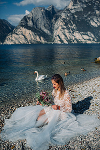 一名女性在意大利一座山和湖的背景下被拍到照片 Torbole Torbole 的作者 Look Garda快乐公主天鹅山脉裙子公图片
